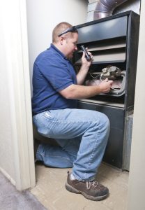 technician checking the inside of a furnace