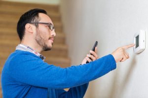 man setting thermostat 