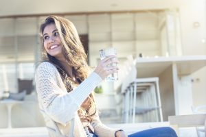 woman-smiling-with-glass-of-water-in-her-hand