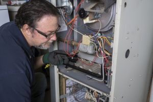 technician-inspecting-and-maintaining-gas-furnace