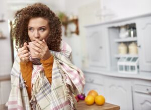 woman-wrapped-in-blanket-sipping-from-mug