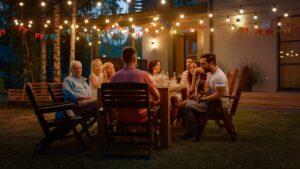 group-of-people-eating-outside-under-lights